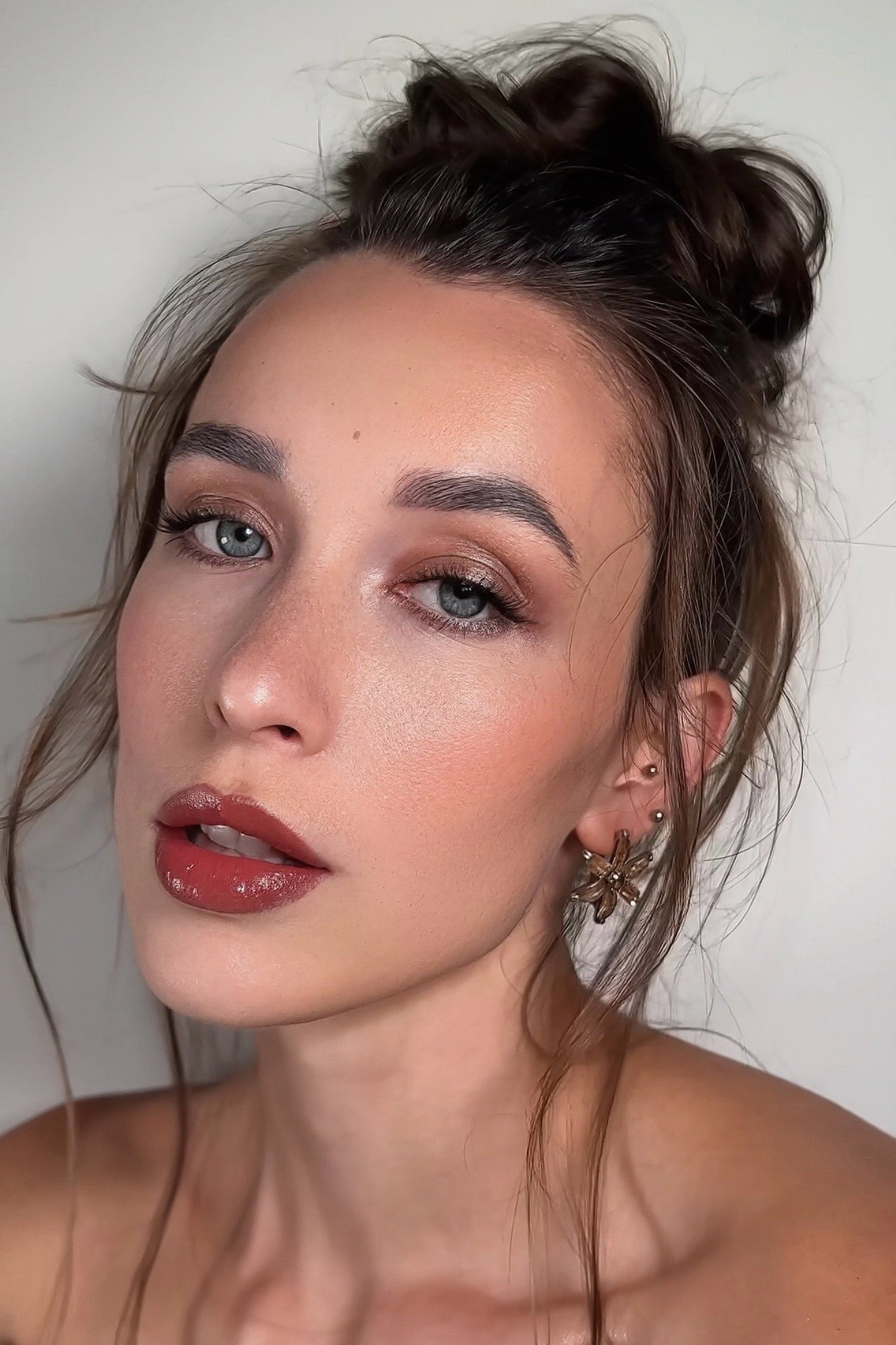 Close-up of a woman with styled hair against a neutral background