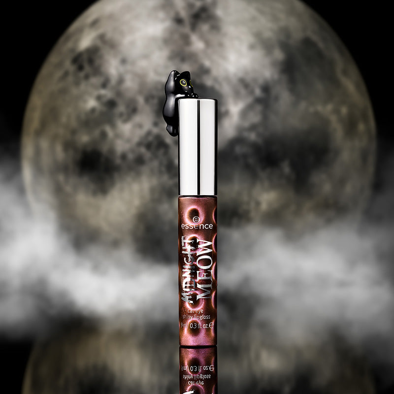 Midnight Meow lip gloss with a black cat perched on the cap, set against a full moon with a smoky, misty background.