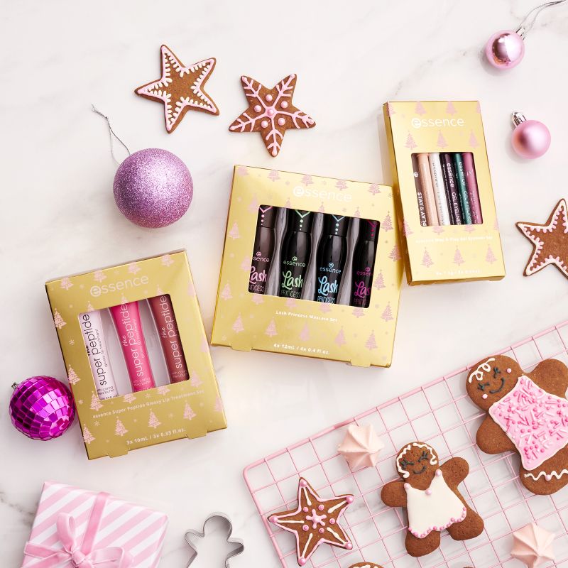Holiday gift sets featuring Lash Princess mascaras, Super Peptide lip treatments, and Stay & Play eyeliners surrounded by festive ornaments and cookies.